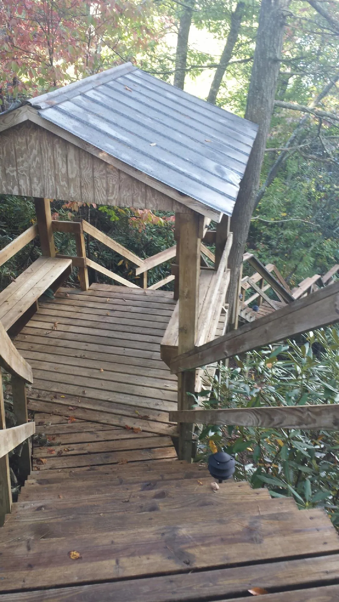 Metal roofed shelter over wooden steps on a wooded walkway — Skylight Repair & Installation work by our crew in Incline Village