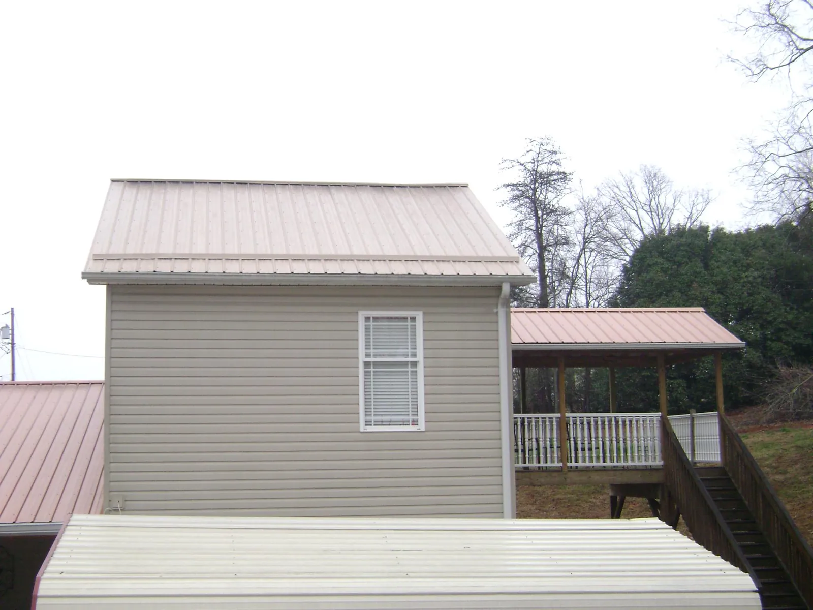 Tan metal roofs on a two story addition and attached porch, from a Roof Replacement job in Incline Village